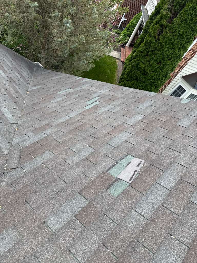 Roofer installing shingles